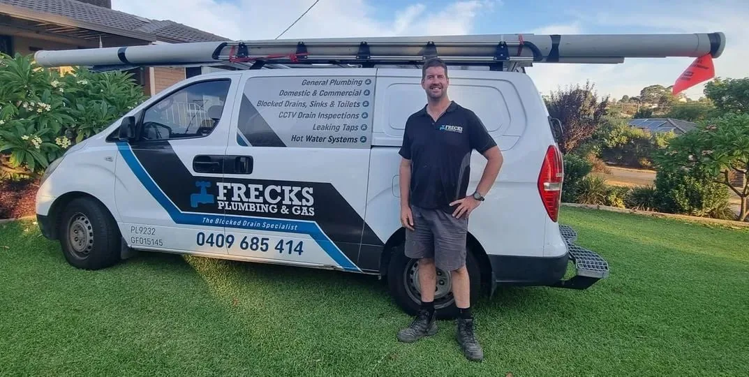 Ben from Frecks Plumbing & Gas in front of his branded work van in Perth's southern suburbs